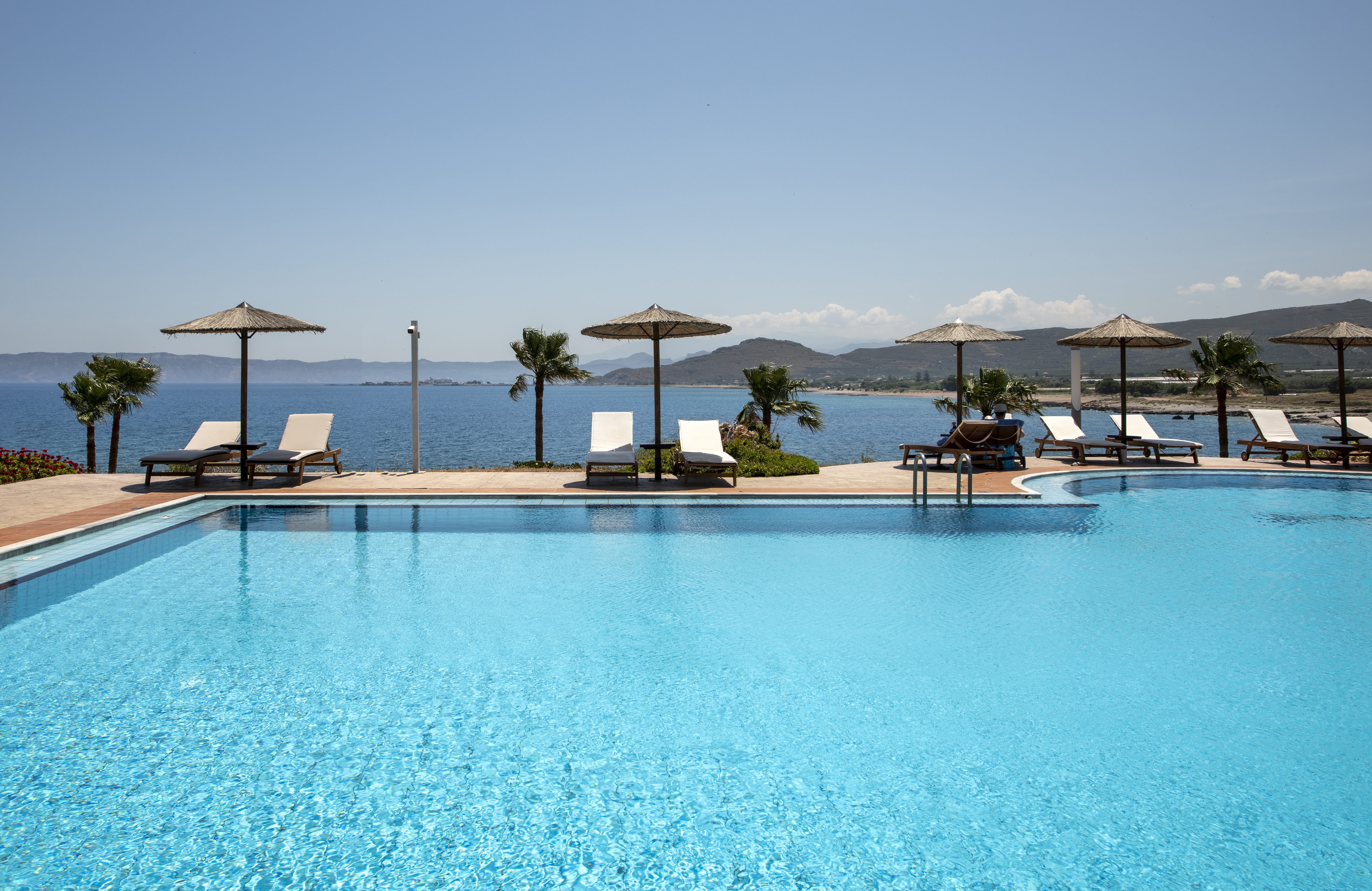 a pool with umbrellas and chairs by it