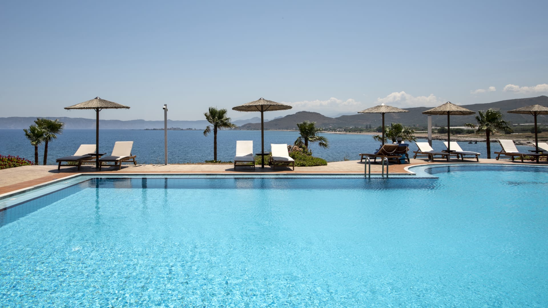 a pool with umbrellas and chairs by it
