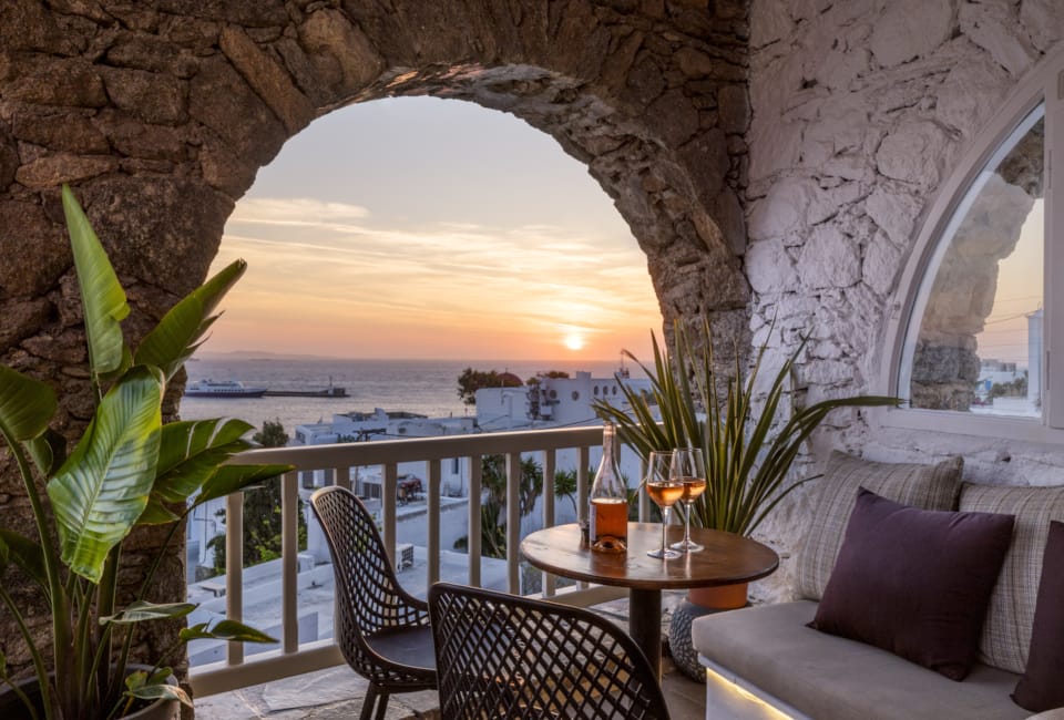 a room with a table and chairs and a view of the ocean