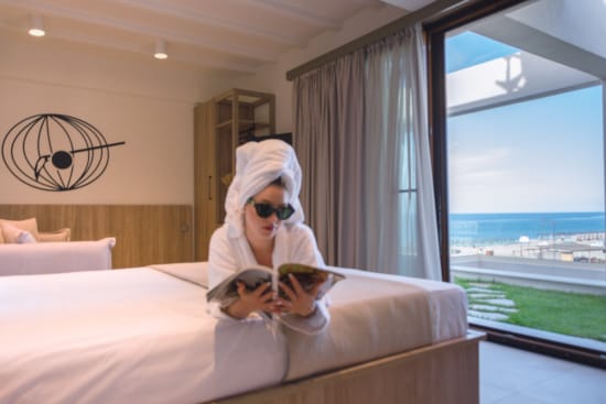 a person in a white garment on a bed with a cat