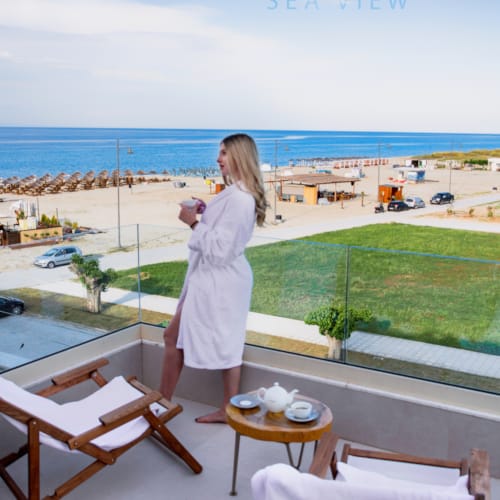 a person standing on a balcony overlooking a beach and ocean