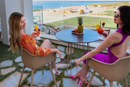 a woman and a child sitting at a table with a drink and fruit on it