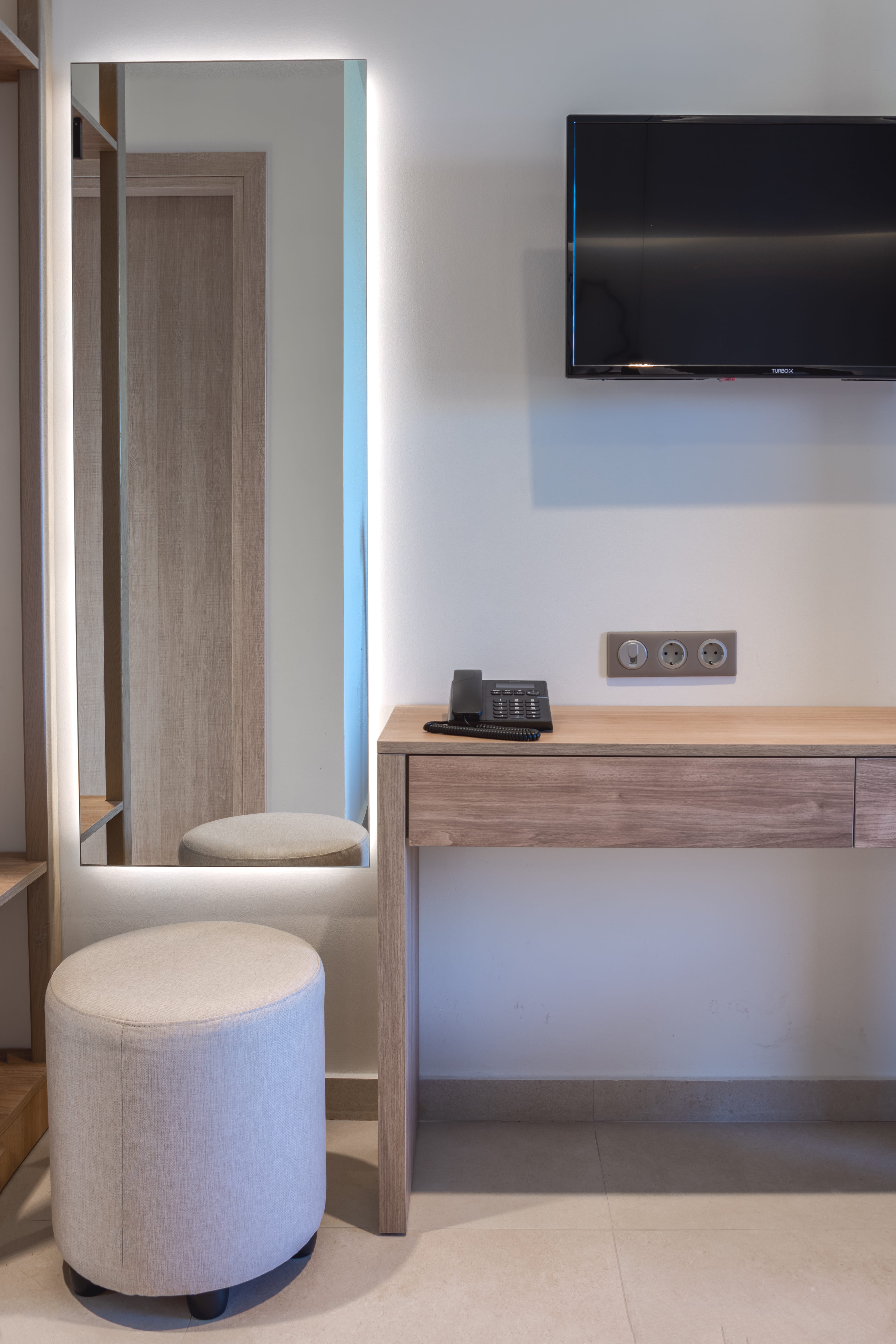 a bathroom with a tv and a stool