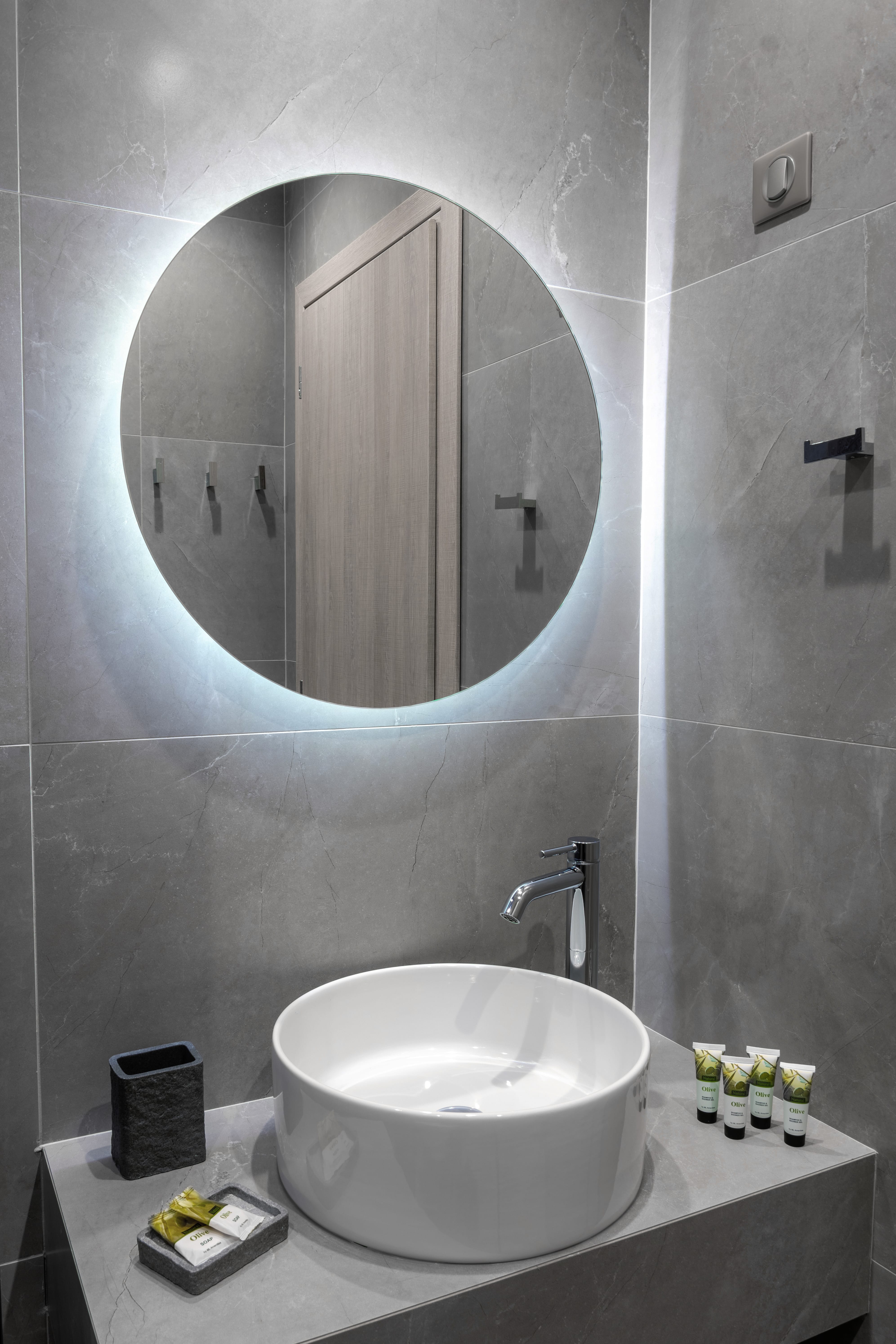 a bathroom with a round mirror