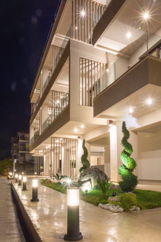 a building with a walkway and plants