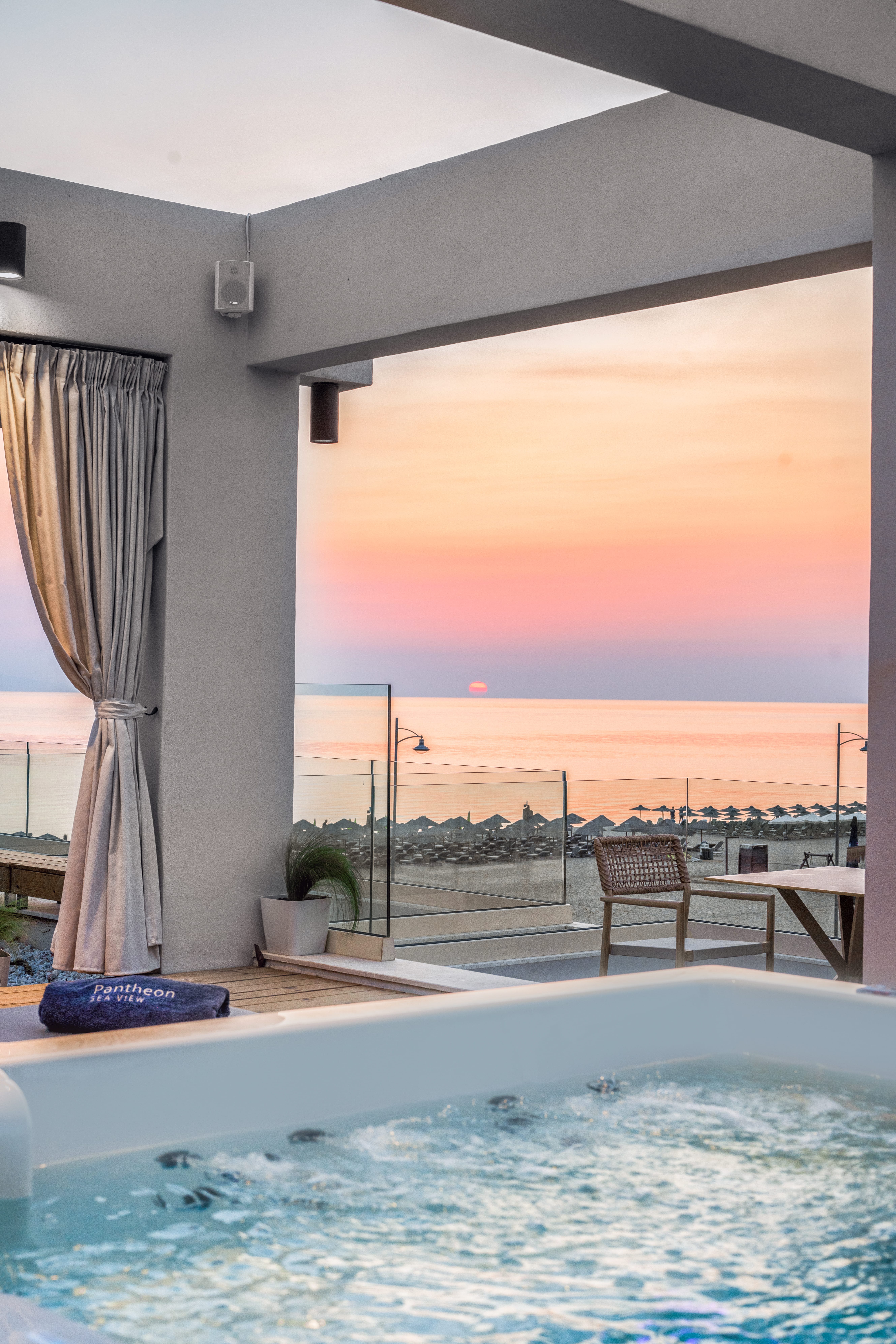 a pool with a view of the ocean and a sunset