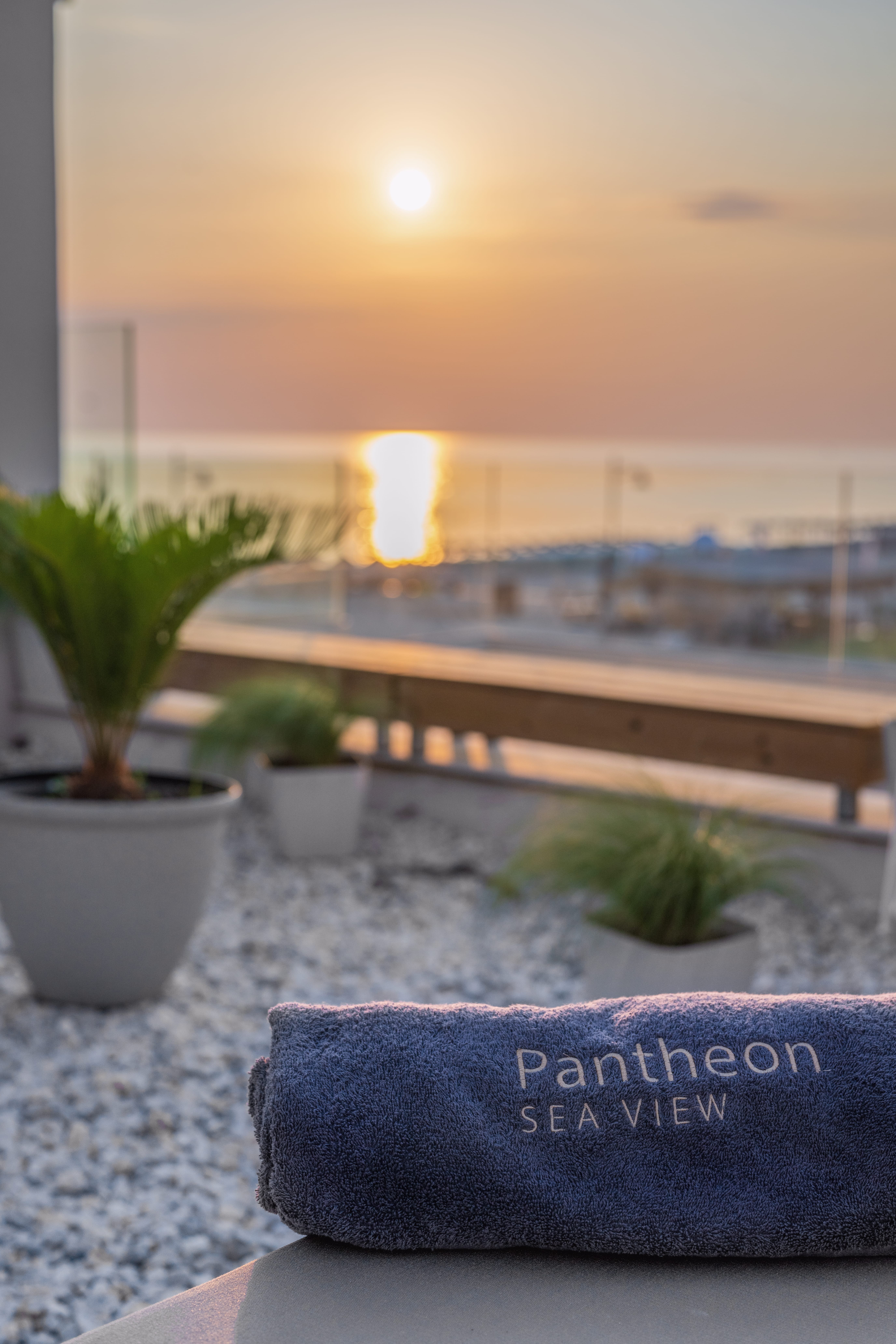 a deck with potted plants and a sunset