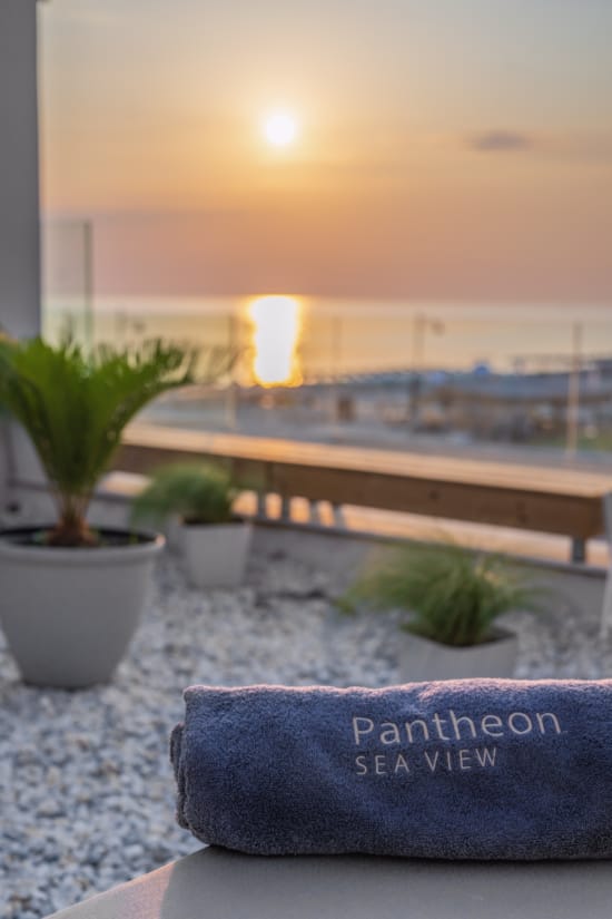 a deck with potted plants and a sunset
