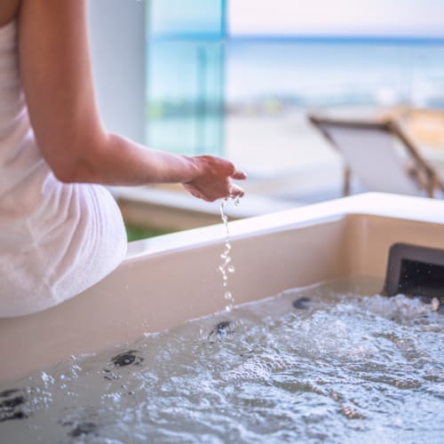 a woman pouring water into a sink