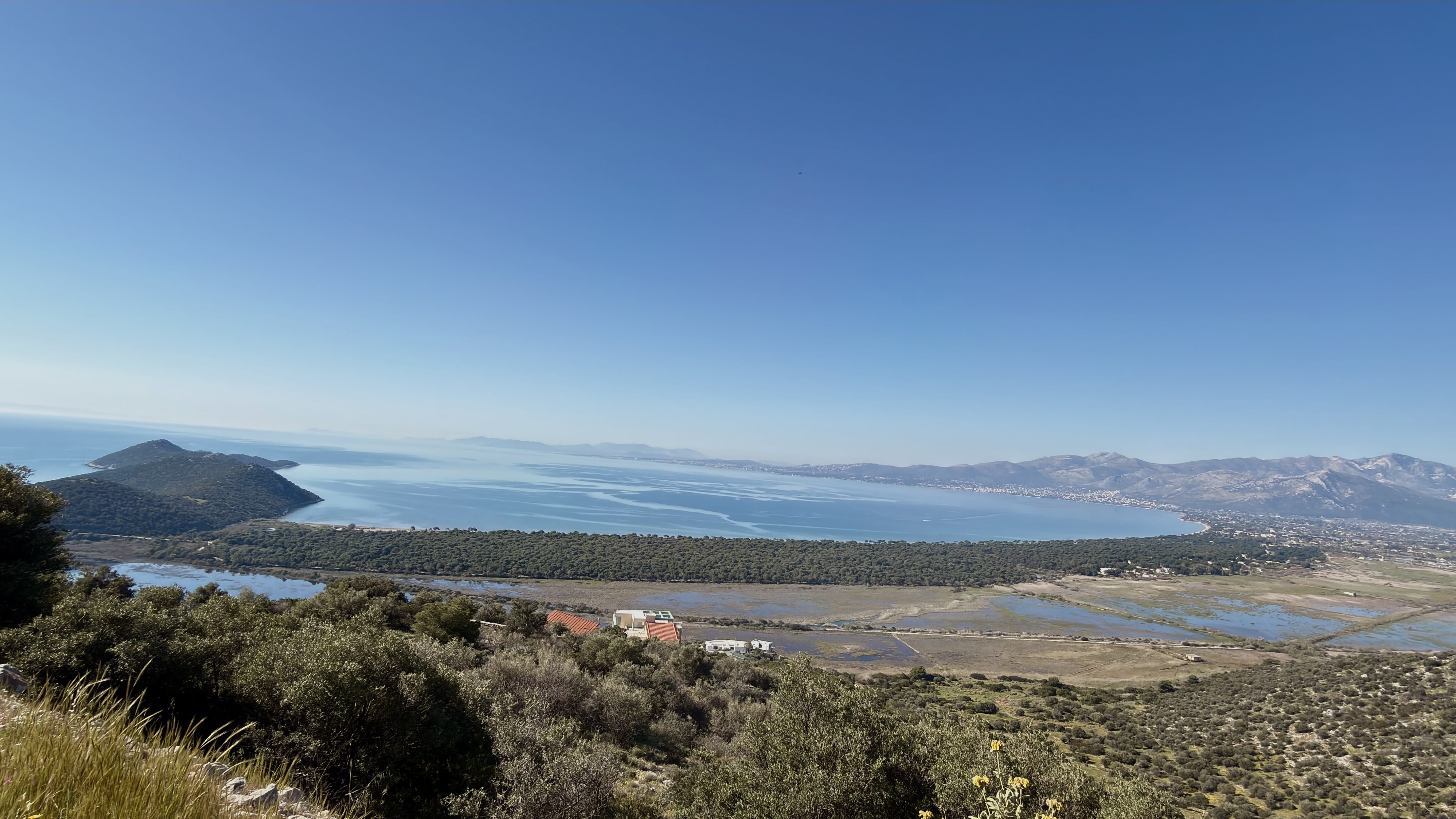 a landscape with a body of water and mountains in the background