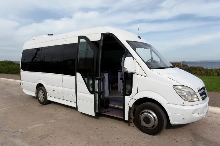 a white bus on a road
