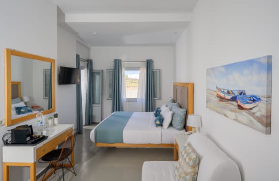 a room with a bed desk and a mirror