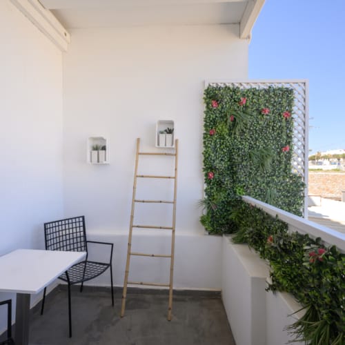 a white building with a table and chairs and a ladder