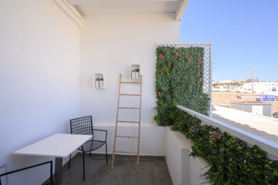 a white building with a table and chairs and a ladder
