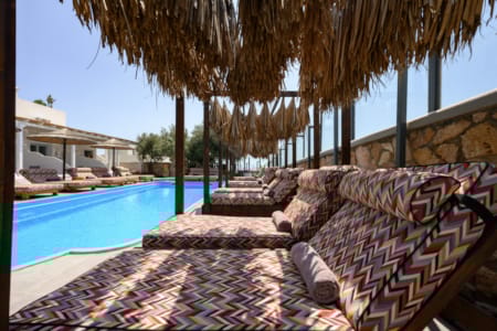 a pool with a lounge chair and a hammock