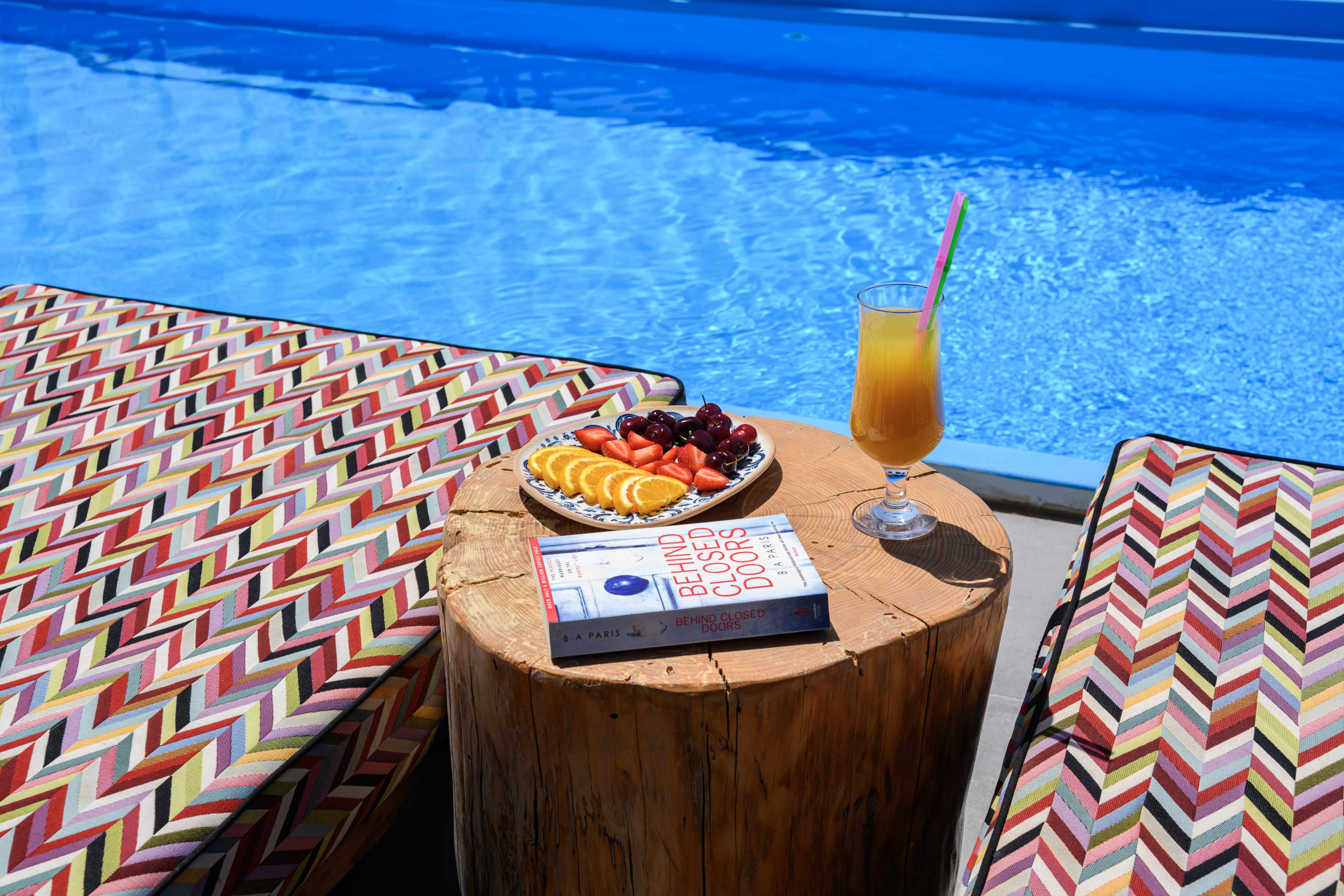 a table with a drink and food on it by a body of water