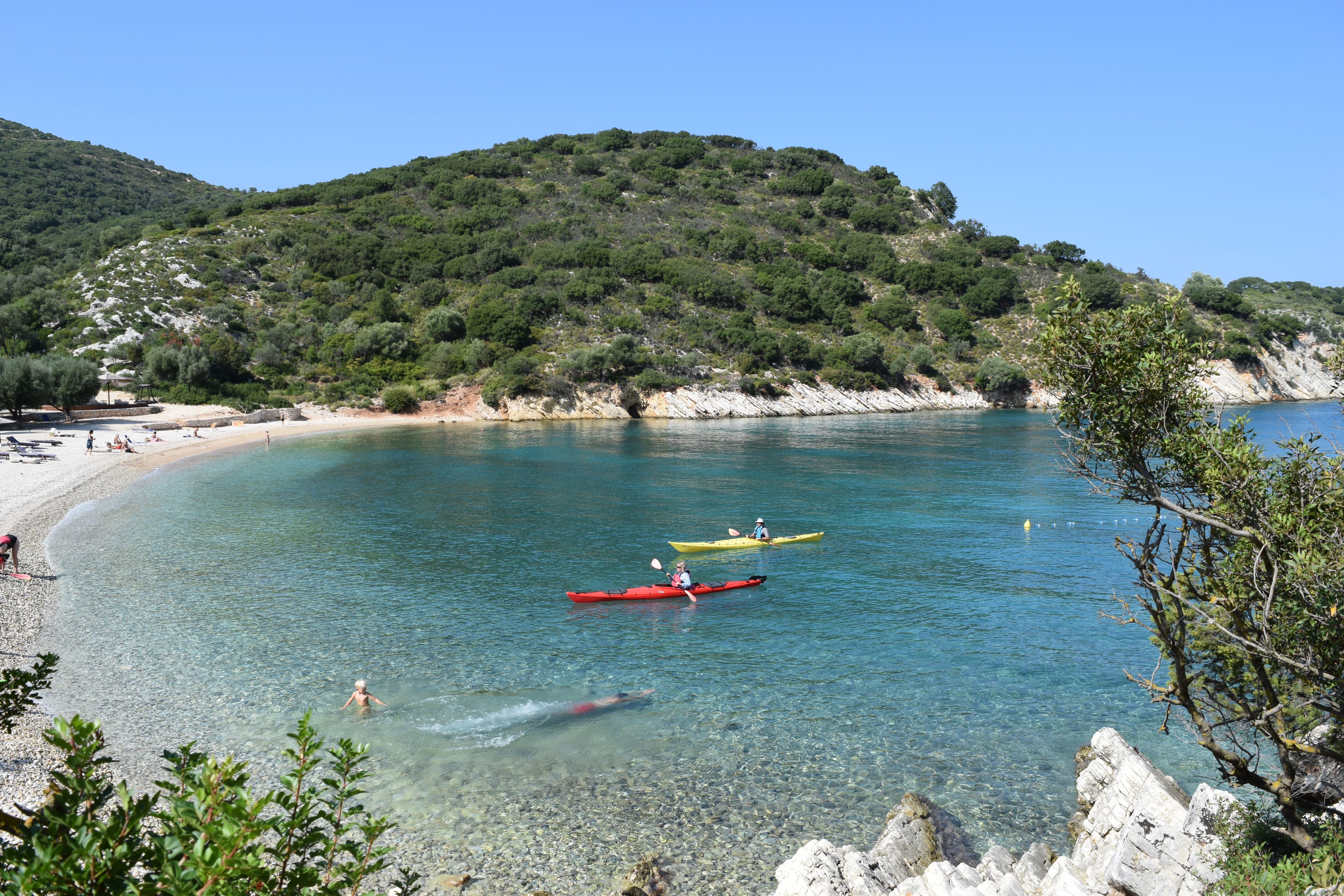 a beach with boats and people