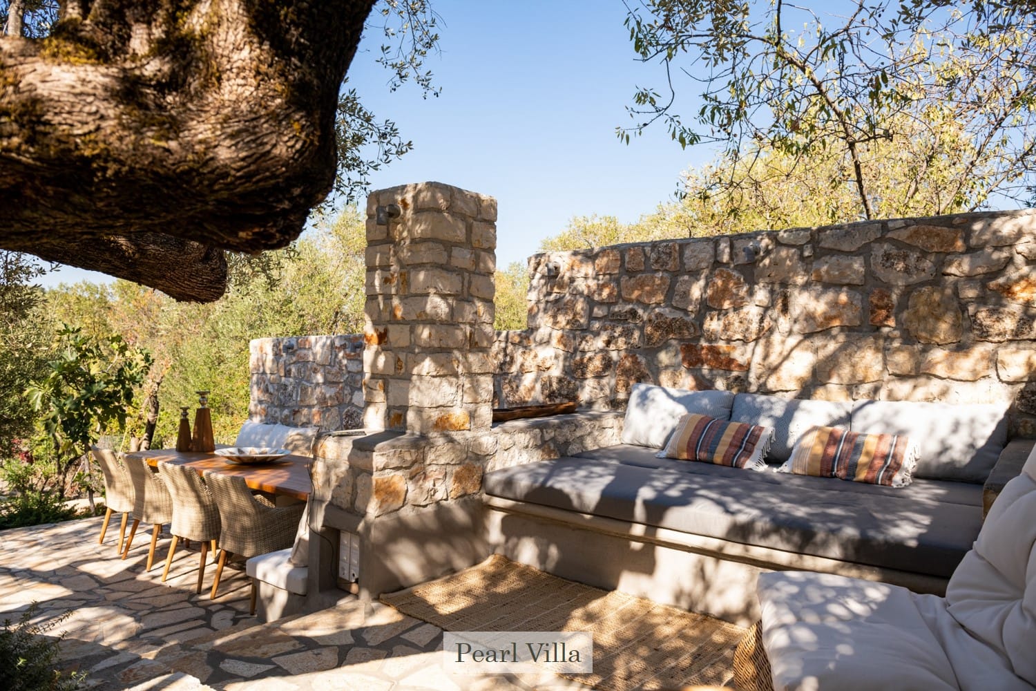 a stone wall with a bench and a table outside
