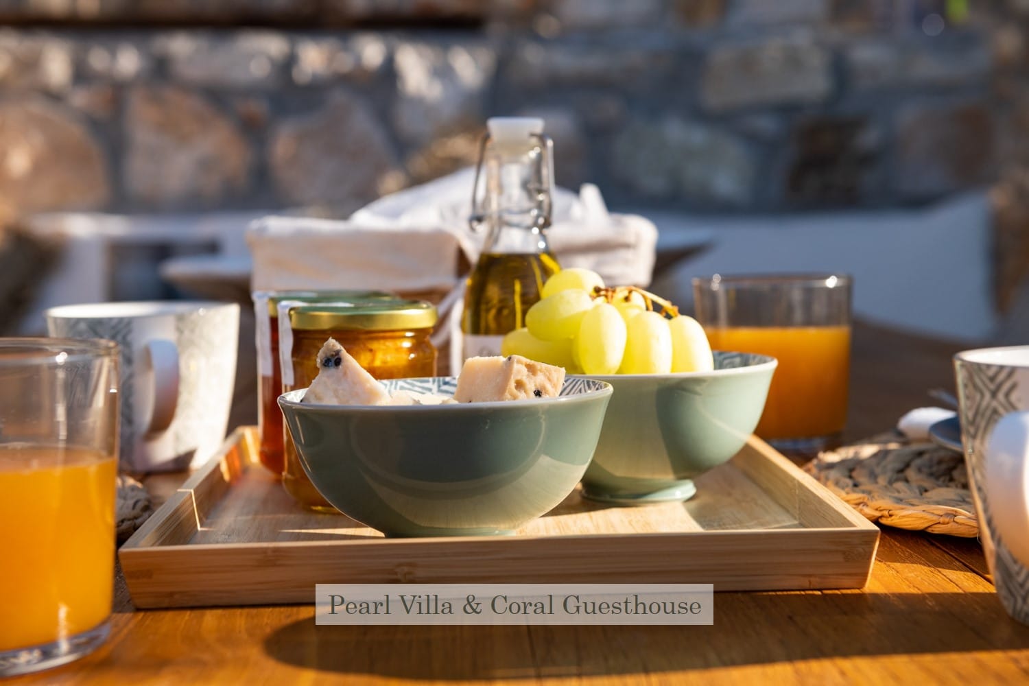 a table with bowls of fruit and a glass of juice