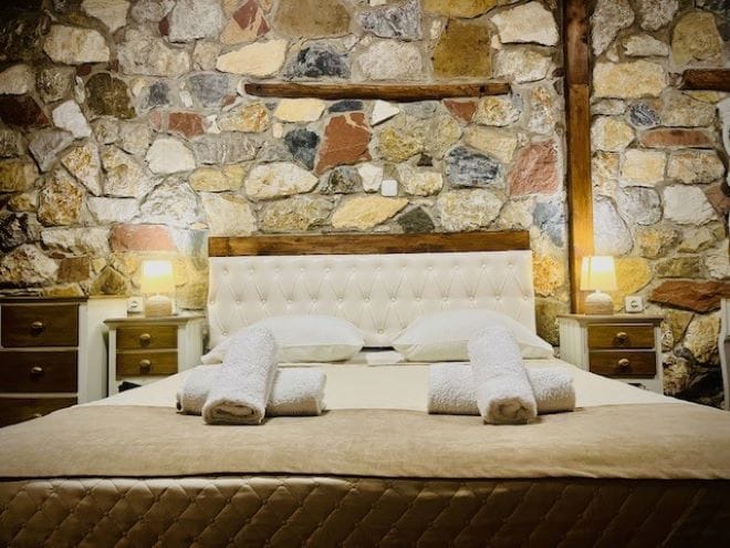 a bed with white sheets and pillows