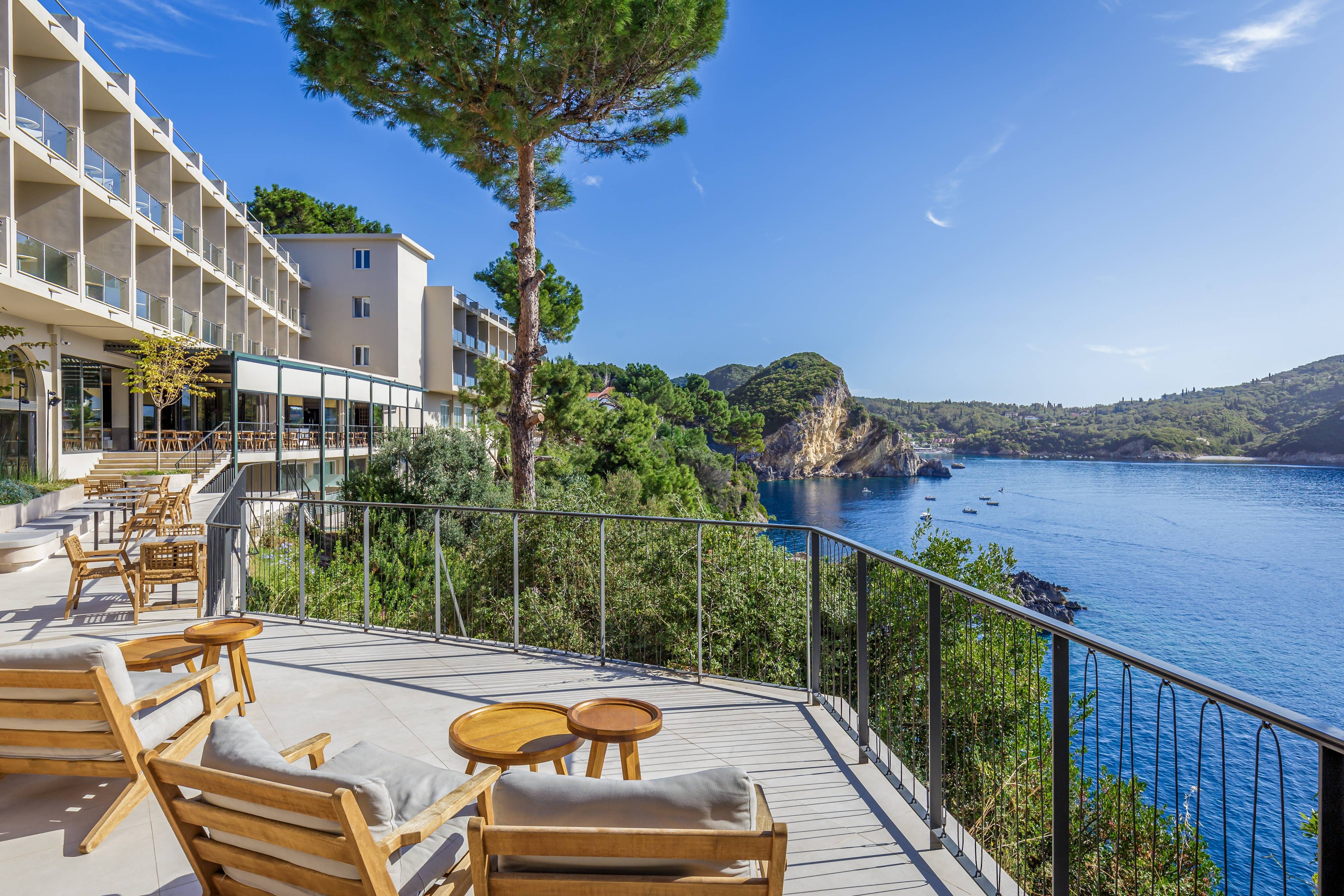 a deck with chairs and tables by a body of water