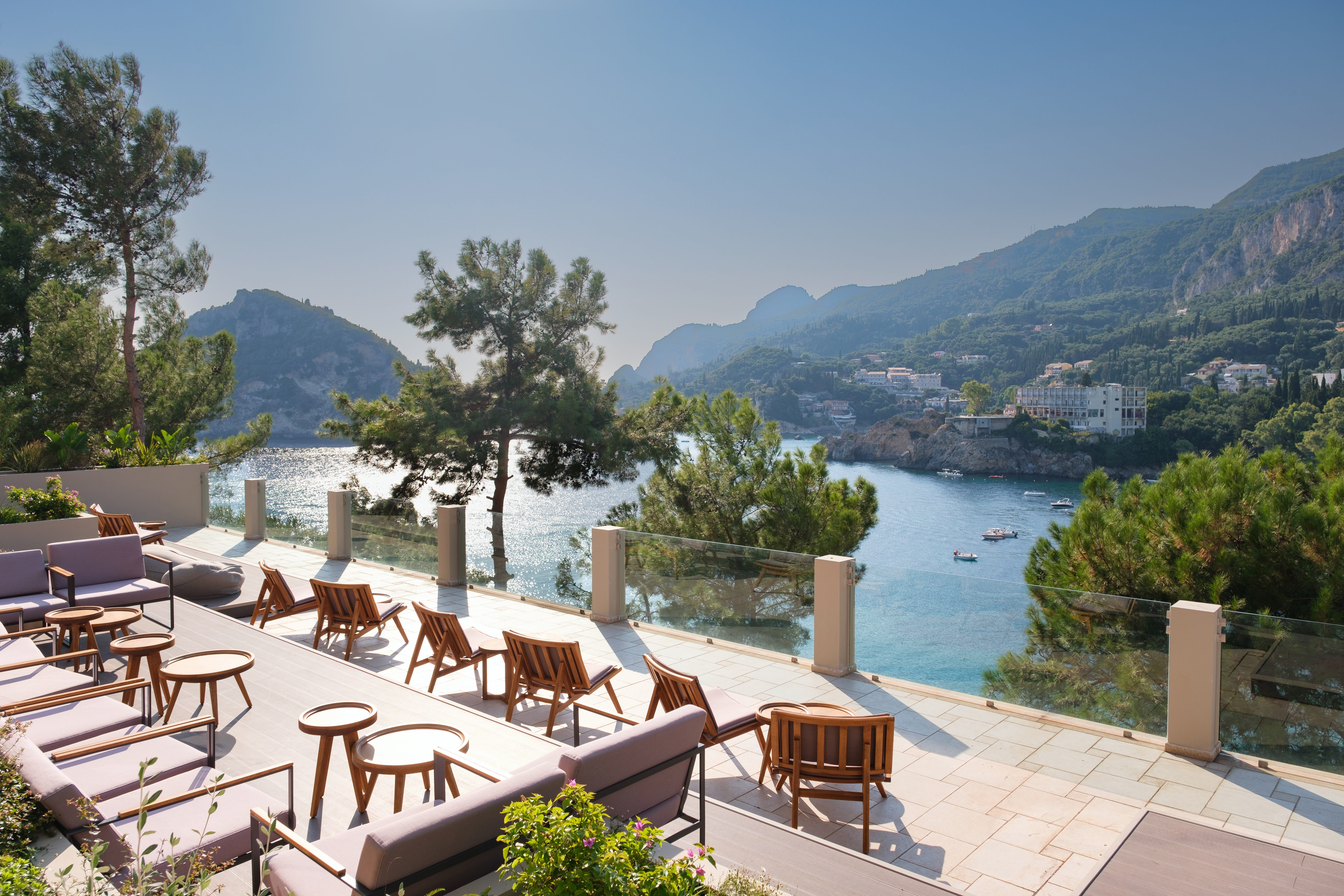 a patio with tables and chairs overlooking a body of water