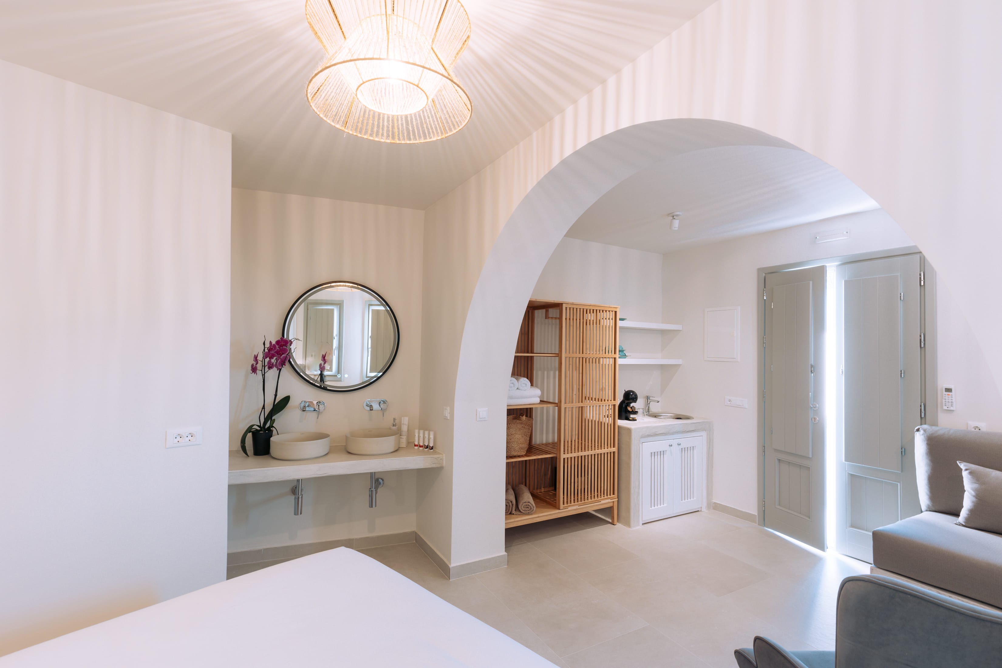 a large white room with a mirror and a sink