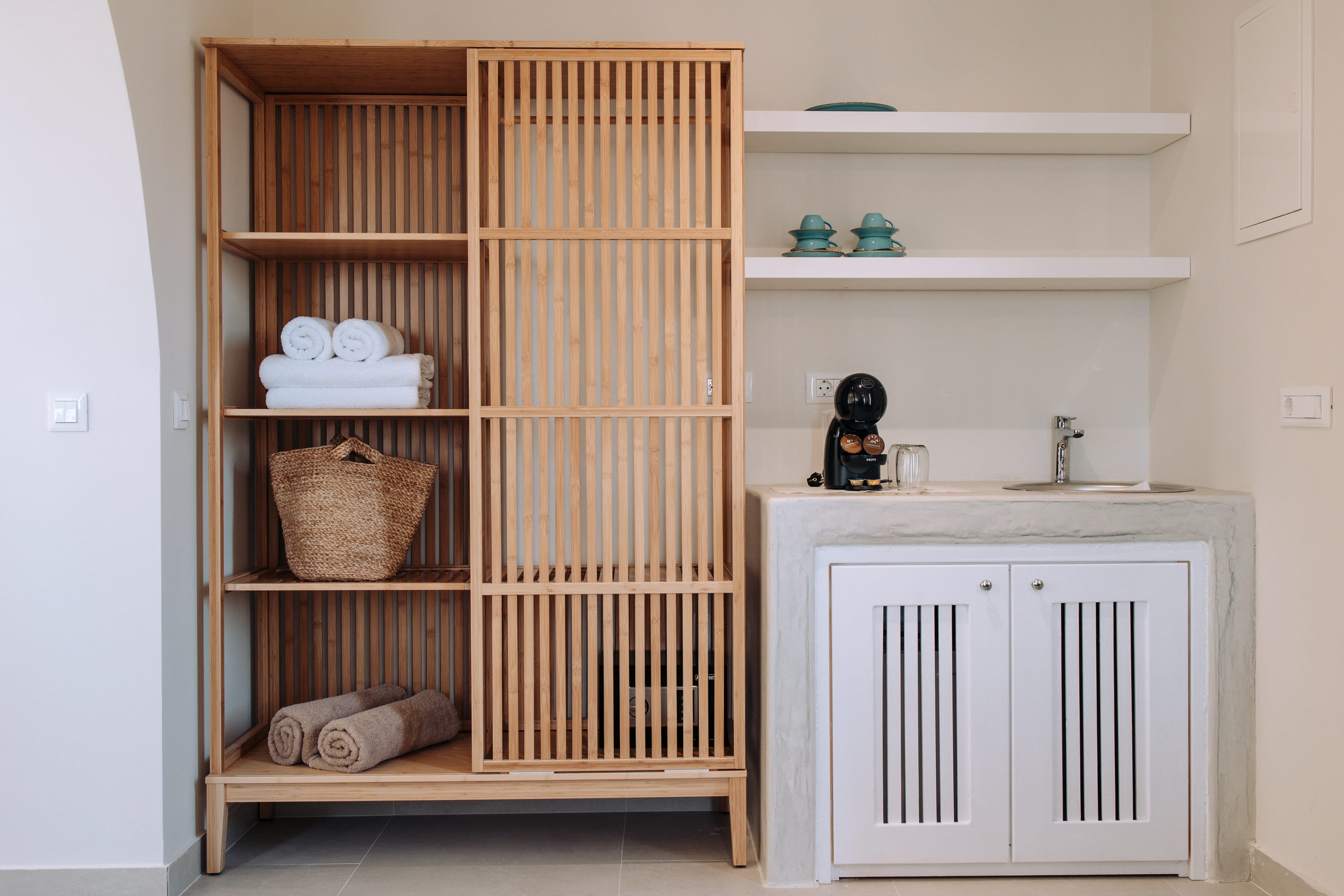a white shelving unit with white cabinets