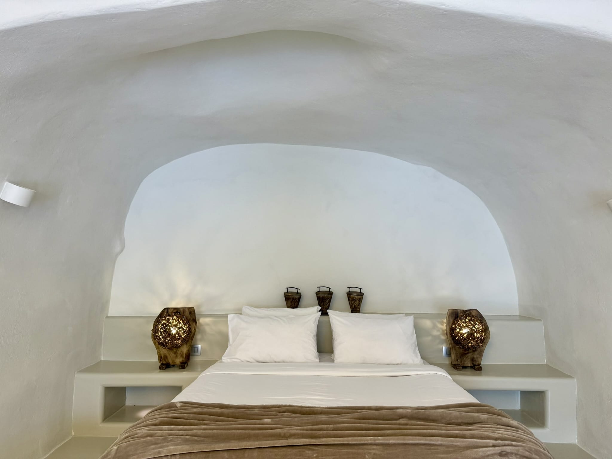 a bed with a white pillow and a white headboard