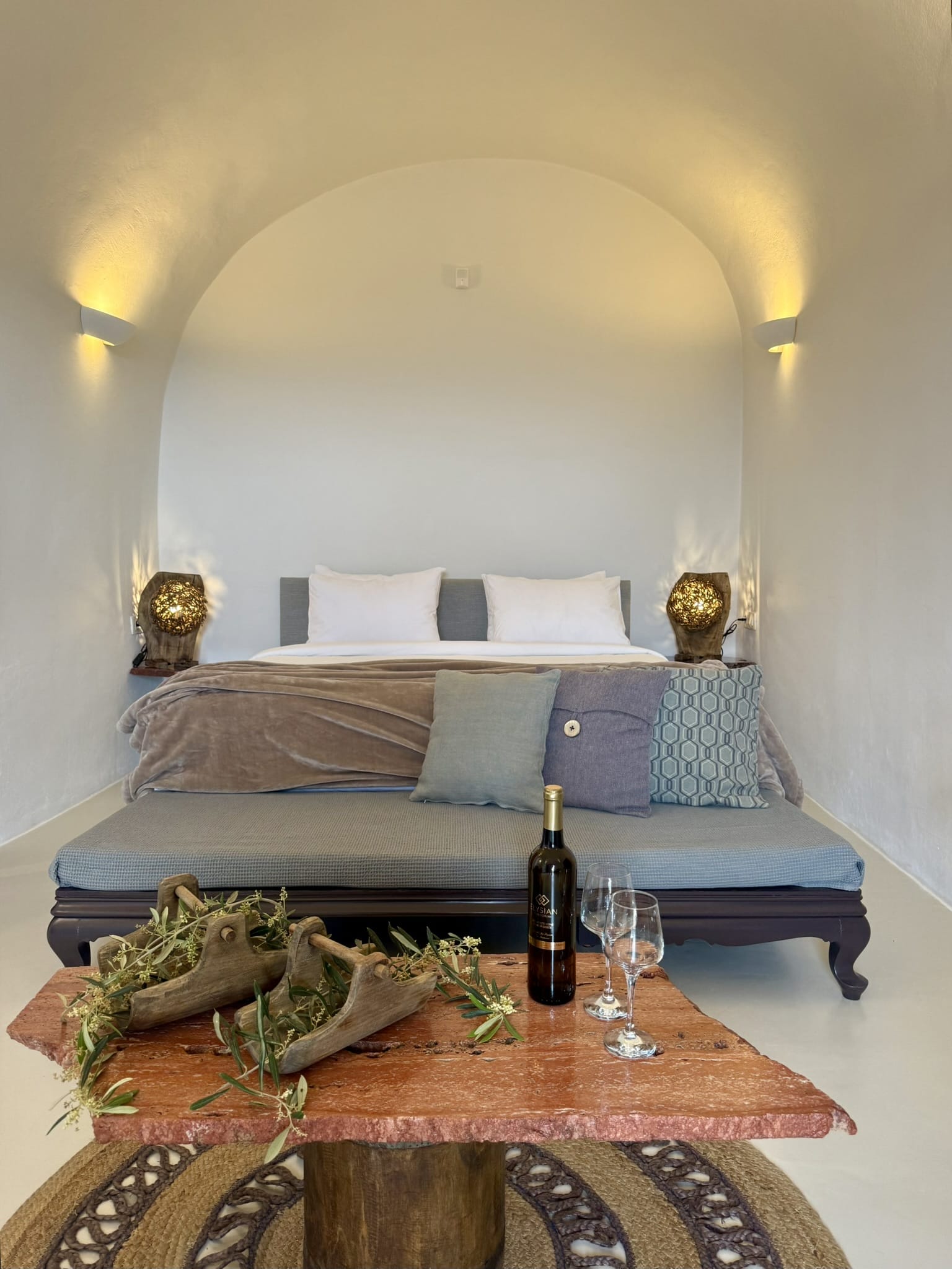 a bed with a wine bottle and glasses on it