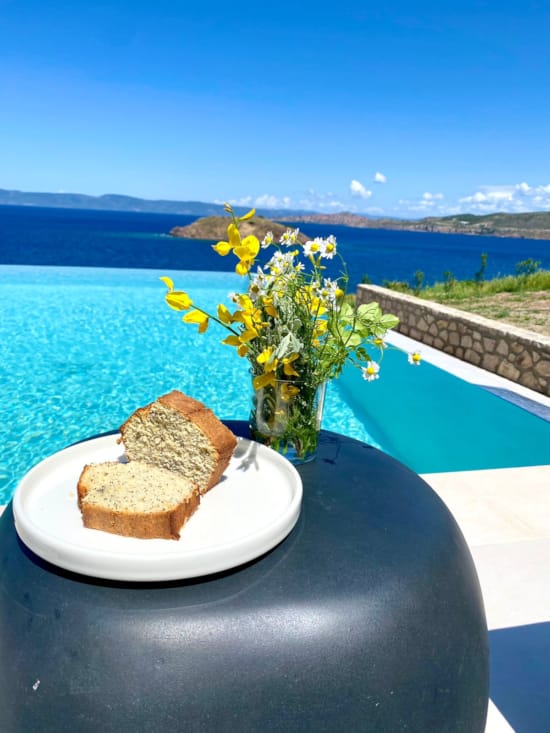 a vase of flowers sits on a table next to a plate of food