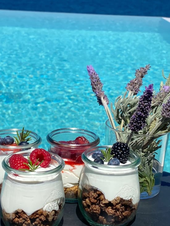 a group of glass jars with plants in them by a body of water