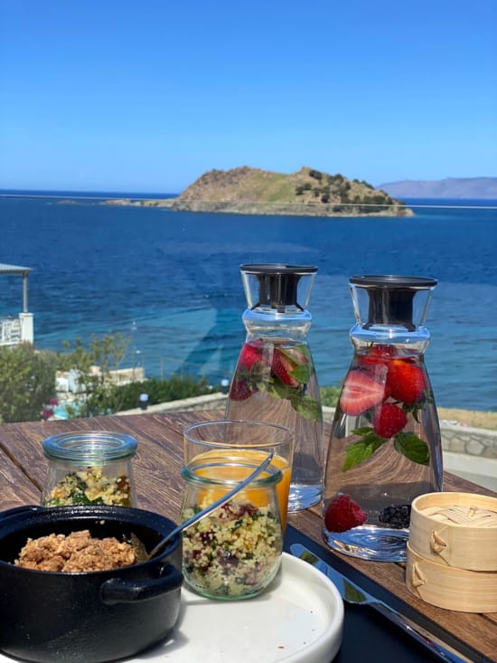 a table with food and drinks on it by a body of water