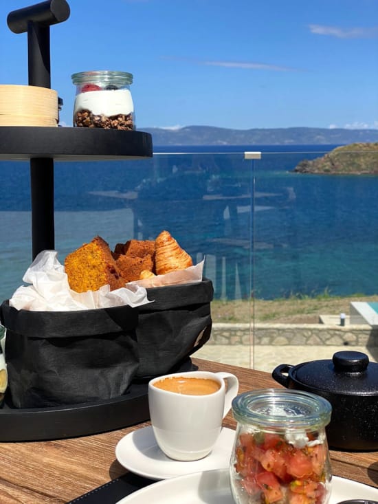 a table with food and drinks on it by a body of water