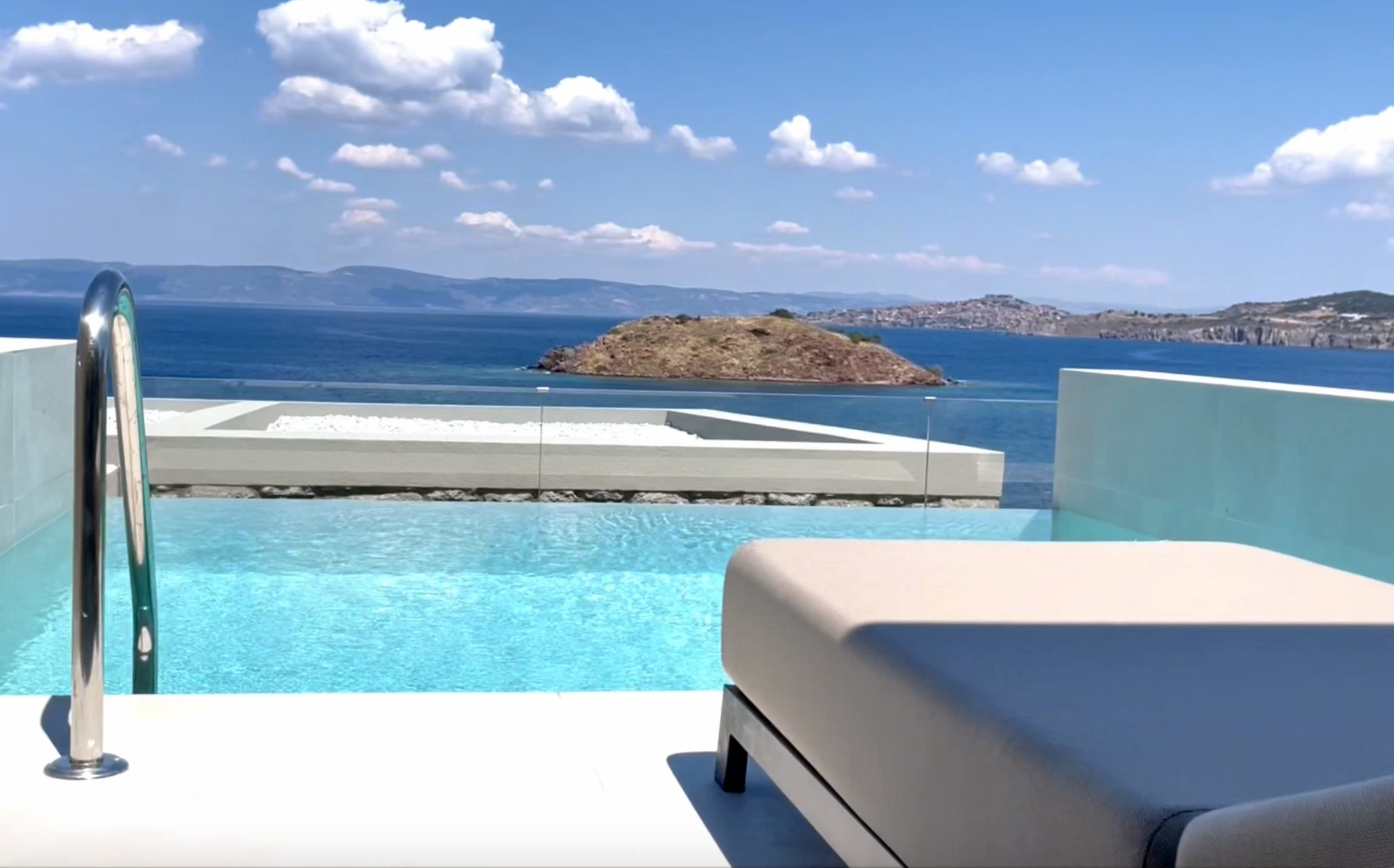 a pool with a view of the ocean and land in the distance