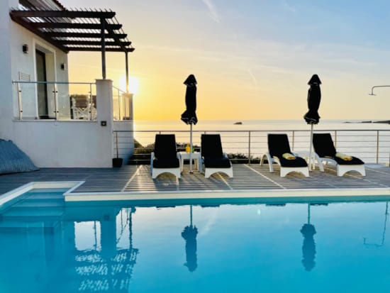 a person standing on a deck next to a pool
