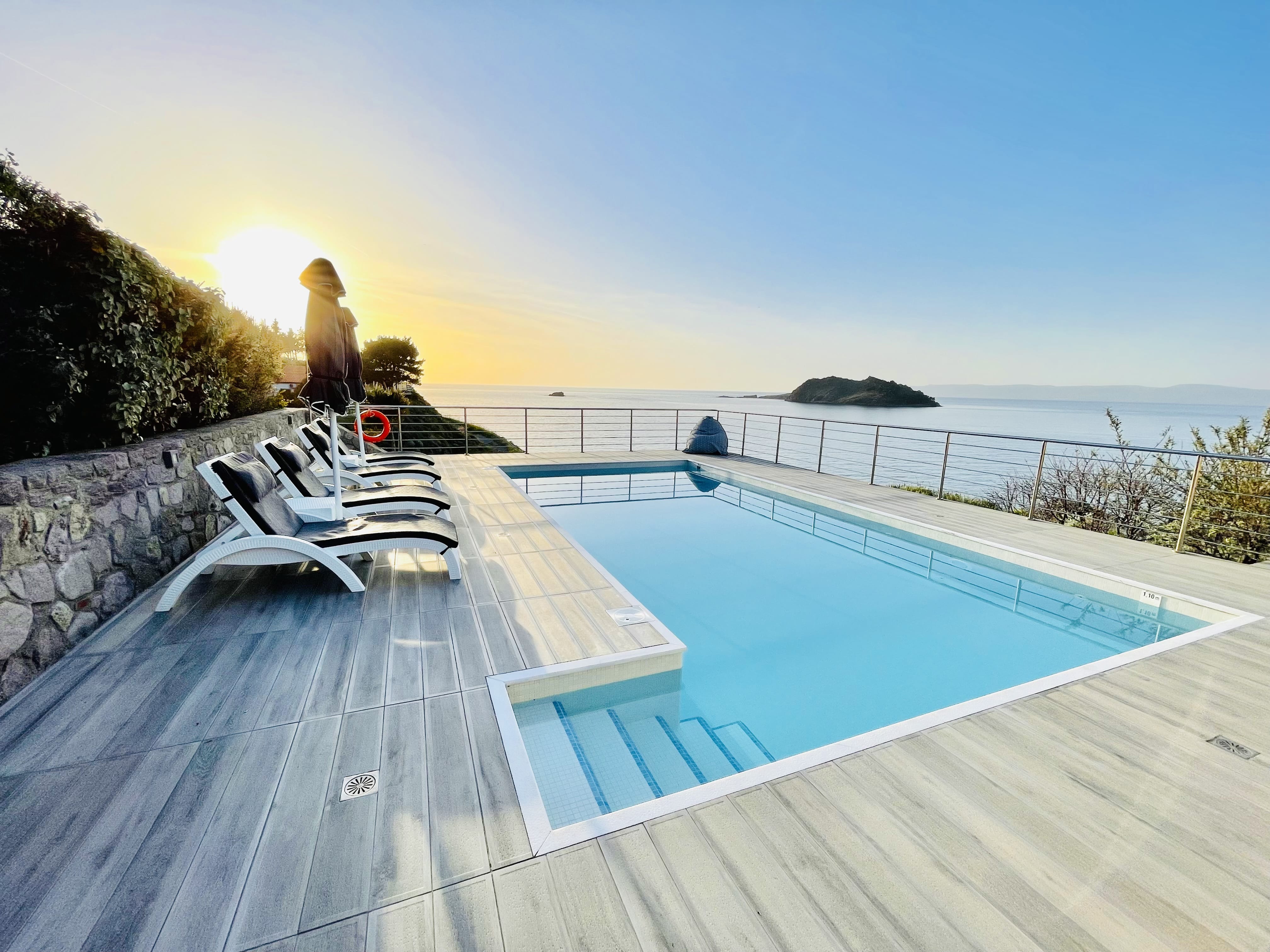 a swimming pool with chairs on the side