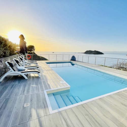 a swimming pool with chairs on the side