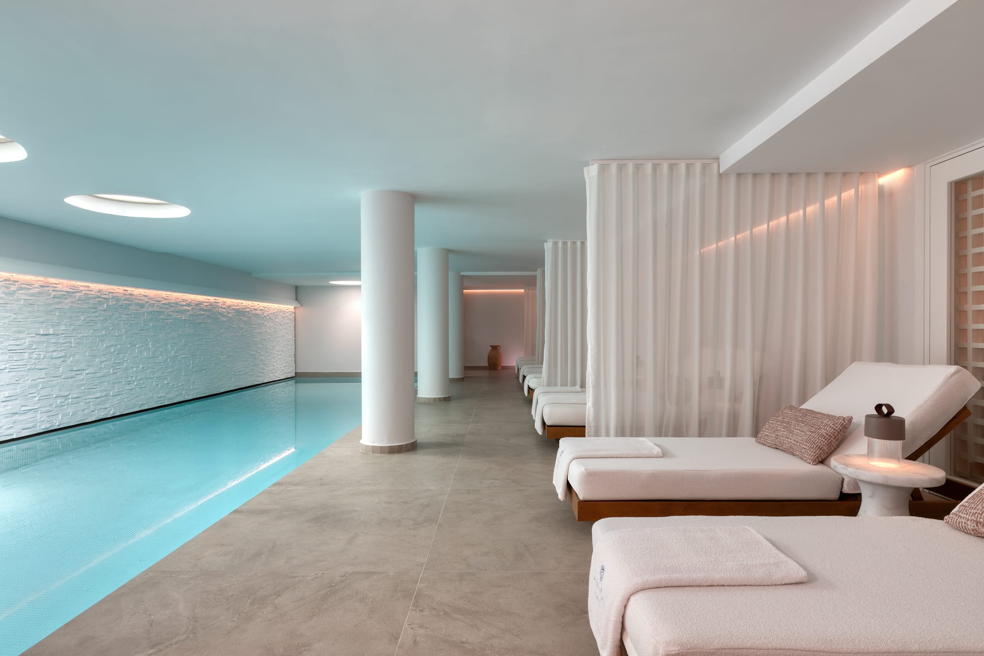a room with white couches and a pool