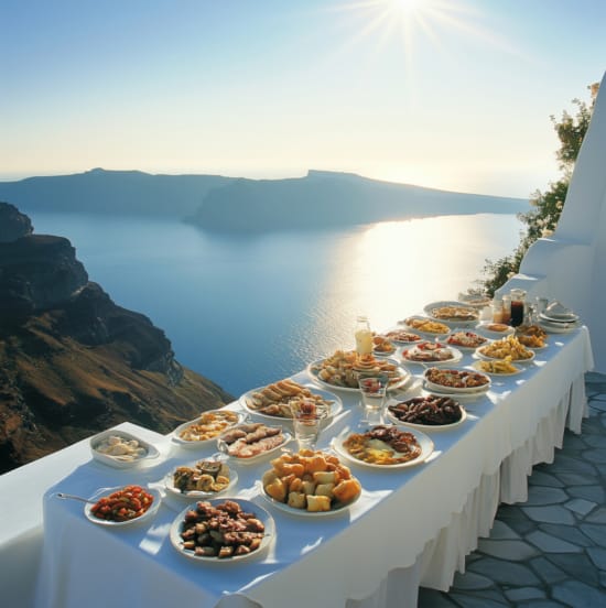 a table with food on it with Santorini in the background