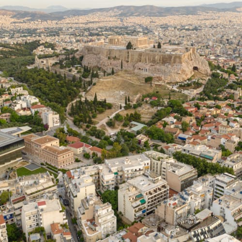 Aerial view of the Acropolis, featuring the Parthenon, amidst the urban landscape of central Athens, near Kyria Boutique House in Plaka.