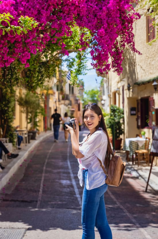 a person taking a picture of a tree with pink flowers