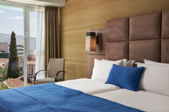 a bed with a chair and a window