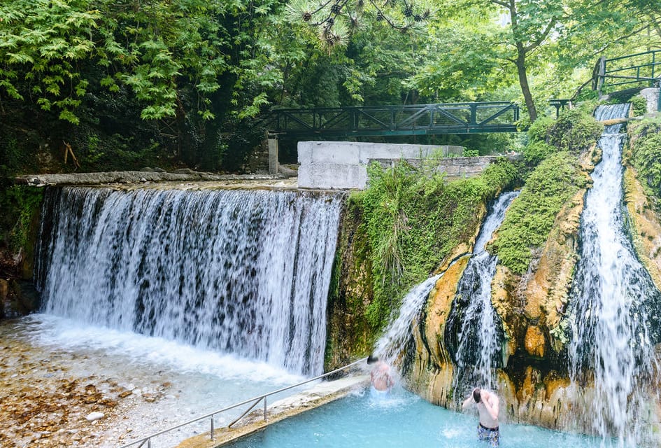 a waterfall with a bridge over it