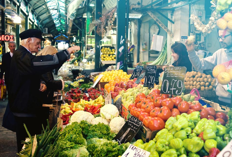 a person standing next to a produce stand