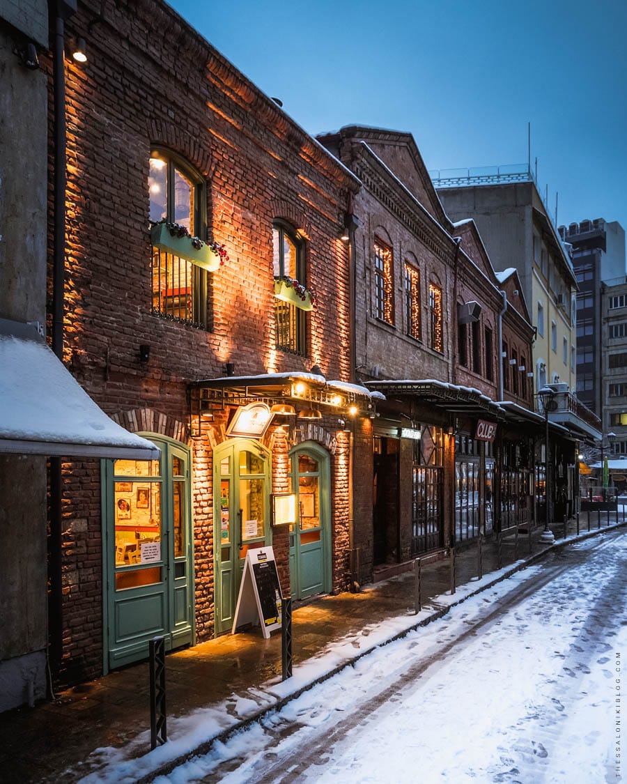 a row of buildings with snow on the ground