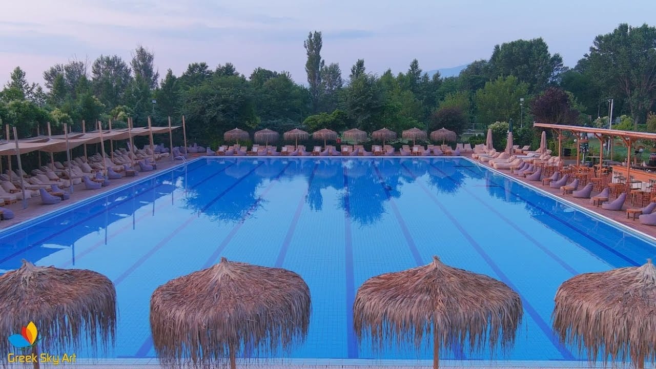 a pool with rocks and trees in the background