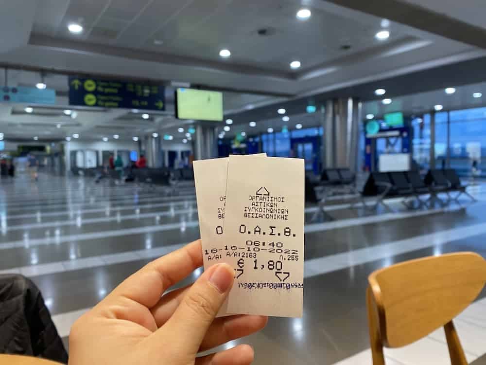 a hand holding a piece of paper in a large room with computers