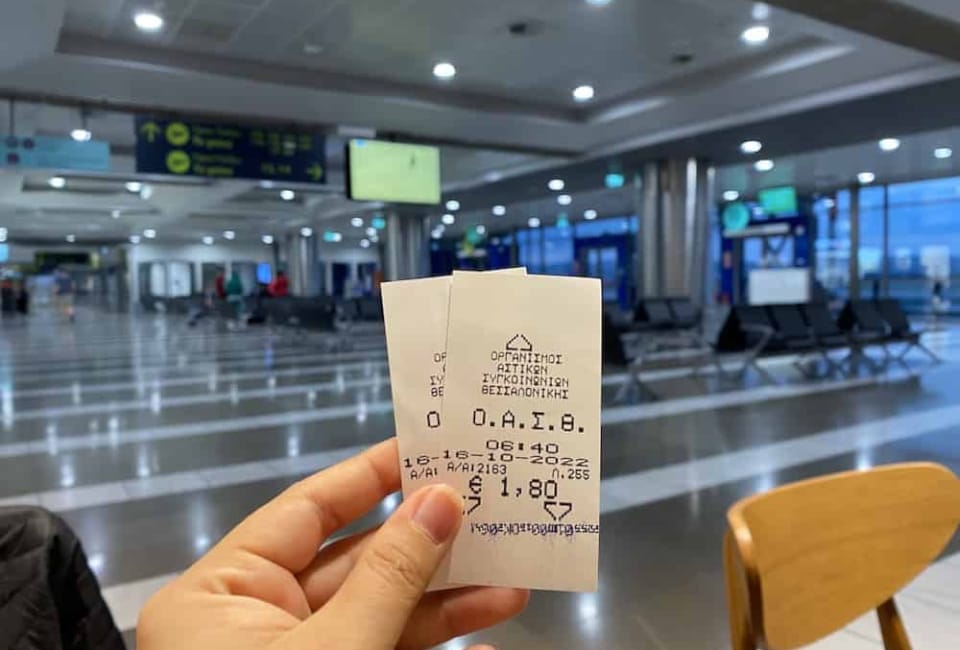 a hand holding a piece of paper in a large room with computers