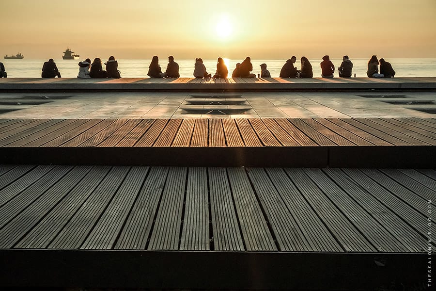a group of people sitting on a dock